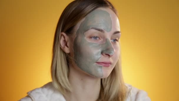 Beautiful blonde getting a facial on a yellow background — Stock Video
