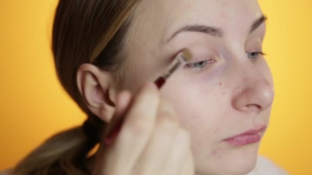 Молодая женщина наносит макияж — стоковое видео
