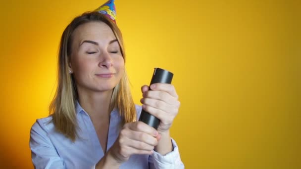 Mujer lanza confeti sobre un fondo amarillo cámara lenta — Vídeos de Stock