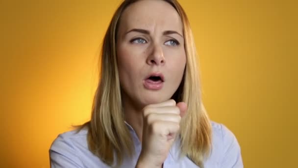 Hustende, an Husten leidende, kranke Frau auf gelbem Hintergrund — Stockvideo