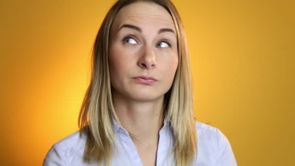 Mujer pensativa se hace una idea sobre fondo amarillo — Vídeos de Stock