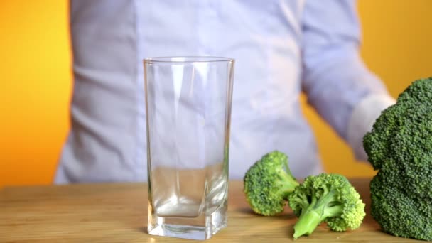 Giovane donna versando un frullato verde sano su un bicchiere — Video Stock