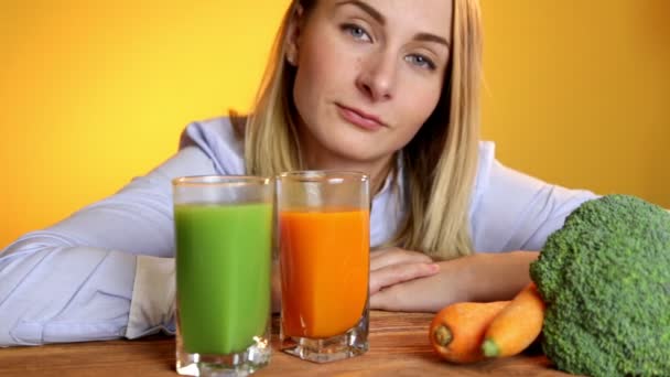 La mujer en la mesa junto a los jugos y verduras — Vídeo de stock