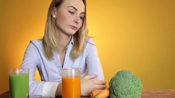 Жінка за столом поруч з соками та овочами — стокове відео