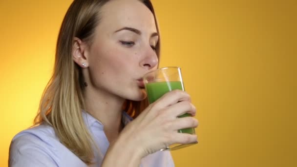 Mujer joven bebiendo batido de verduras verdes — Vídeo de stock