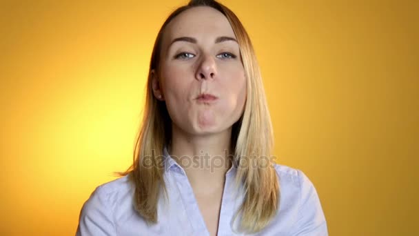 Leuke vrouw eten van ijs op een gele achtergrond. — Stockvideo