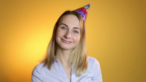 Krásná dívka foukání balónků na žlutém podkladu — Stock video