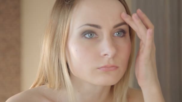 Женщина проверяет свои морщины на лбу — стоковое видео
