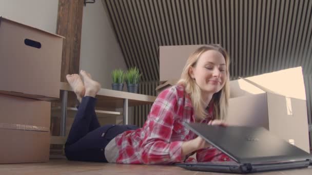 Kobieta siedziała przez rozpakowanych pudeł z laptopa — Wideo stockowe