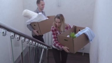 Genç çift yeni evde kutuları ile merdivenlerden yukarı
