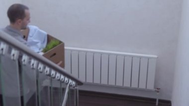 Genç çift yeni evde kutuları ile merdivenlerden yukarı