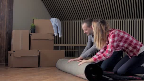 Couple rolling out carpet for their new house — Stock Video