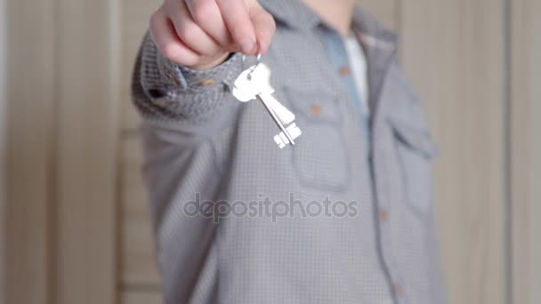 Feliz joven sonriente mostrando un par de llaves de su nueva casa — Vídeos de Stock