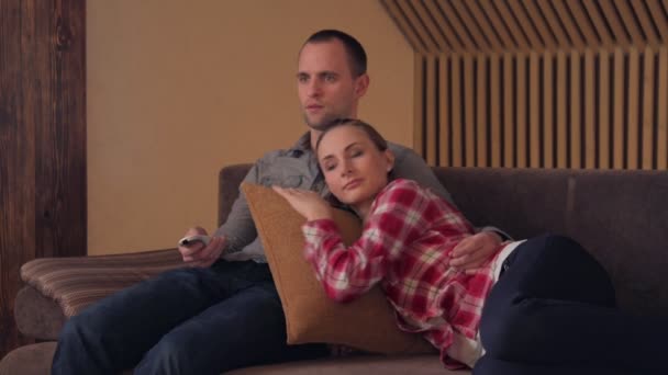 Пара дивиться комедію на телевізорі на дивані — стокове відео