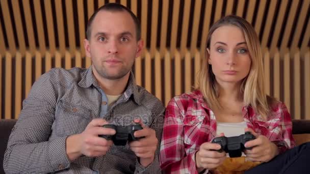 Pareja feliz jugando videojuegos en el sofá — Vídeos de Stock