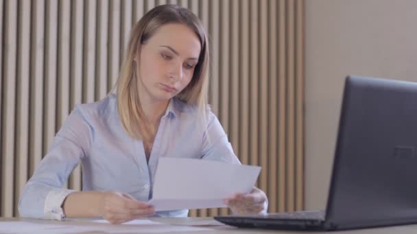 Depressed woman checking her expenses in her living room — Stock Video