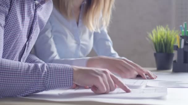 Team of two architects, sitting at desk in office with building plans. — Stock Video