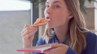 Bir dilim pizza yeme genç kadın portresi