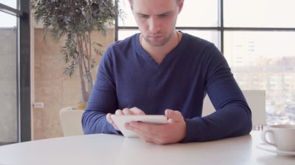 Businessman working on tablet computer and drinking coffee in cafe — Stock Video