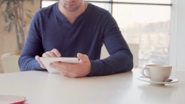 Бізнесмен, що працює на планшетному комп'ютері та п'є каву в кафе — стокове відео