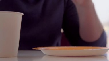 Genç adam yeme sandviç, restoranda kahvaltı