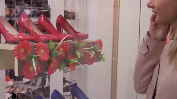 Gelukkig jonge vrouw kiezen van schoenen en lachend in schoenenwinkel — Stockvideo