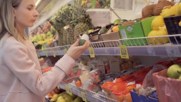 Женщина выбирает фрукты в супермаркете в формате 4k высокого качества — стоковое видео