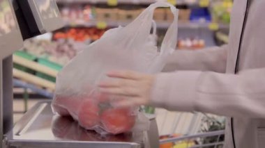 Genç kız biber süpermarkette ölçeklerde tartılır.