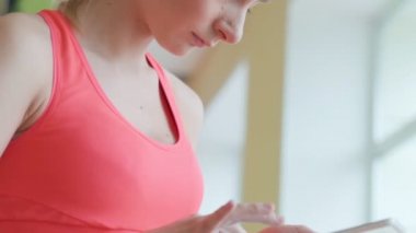 Oturma ve spor salonunda tablet kullanarak mutlu sevimli genç sporcumuz