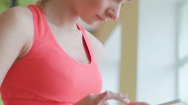 Oturma ve spor salonunda tablet kullanarak mutlu sevimli genç sporcumuz