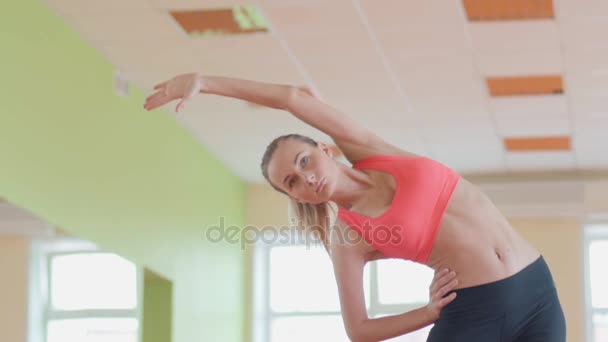 Chica atlética delgada haciendo ejercicios de yoga en interiores. Estiramiento . — Vídeo de stock