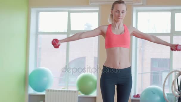 Решительная женщина теряет вес и упражняется с гантелями — стоковое видео