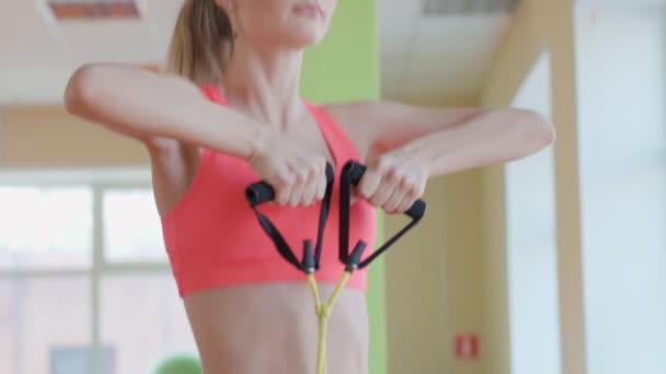 Chica agradable posando con expansor en la sala de fitness — Vídeo de stock