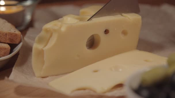 Una mujer corta el queso Maasdam — Vídeo de stock