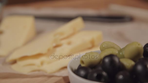 Женщина берет оливку с тарелки — стоковое видео
