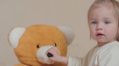 küçük kız evde oyuncak ayı ile oynamak