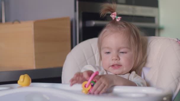小さな女の子がおもちゃと笑顔で遊ぶ — ストック動画