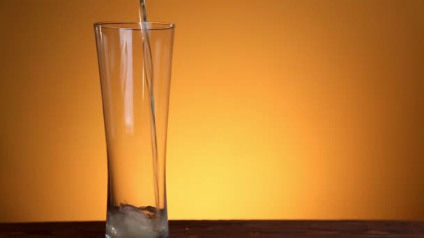 Piwo wylał w szkło na żółtym tle — Wideo stockowe