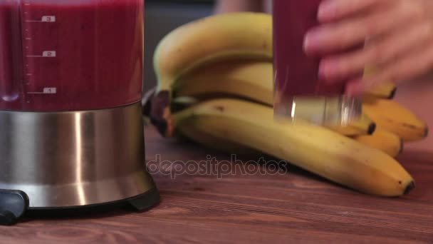 Dolly: Mano femenina tomando un vaso de leche fresca y licuado de fresa de la mesa . — Vídeos de Stock