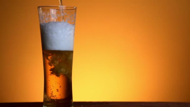 Cerveja derramada em vidro sobre fundo amarelo — Vídeo de Stock