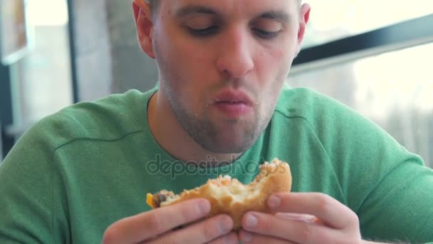 Hombre disfrutando comiendo su hamburguesa — Vídeos de Stock