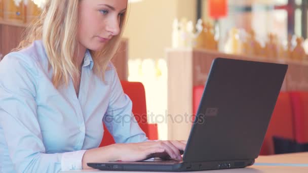 Mujer joven feliz usando tableta en la cafetería — Vídeos de Stock