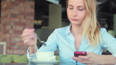 Smartphone gülümseyen ve cep telefonunda manifatura app kullanan kadın.