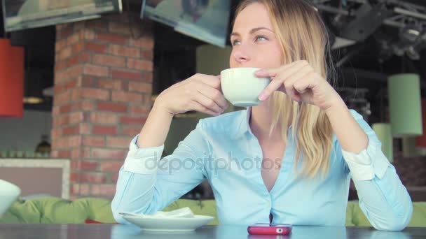 Jovem mulher atraente bebendo café no café — Vídeo de Stock