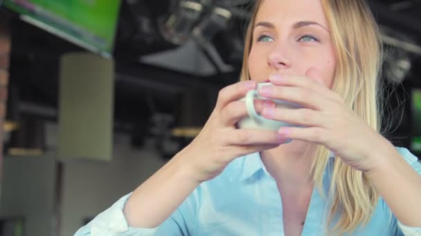 Young attractive woman drinking coffee in cafe — Stock Video