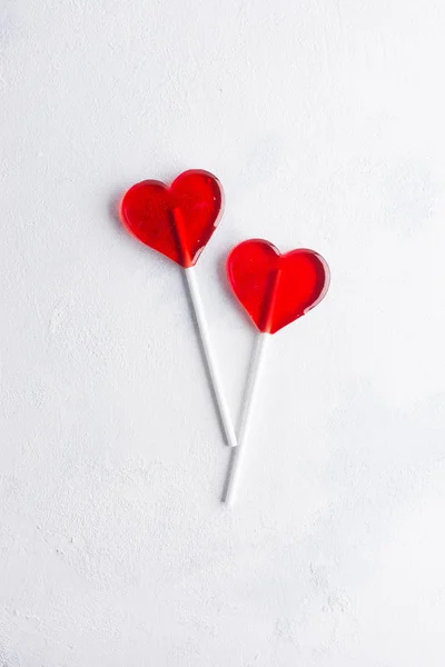 Deux cœurs de bonbons rouges sur fond de béton blanc. Amour minimal — Photo