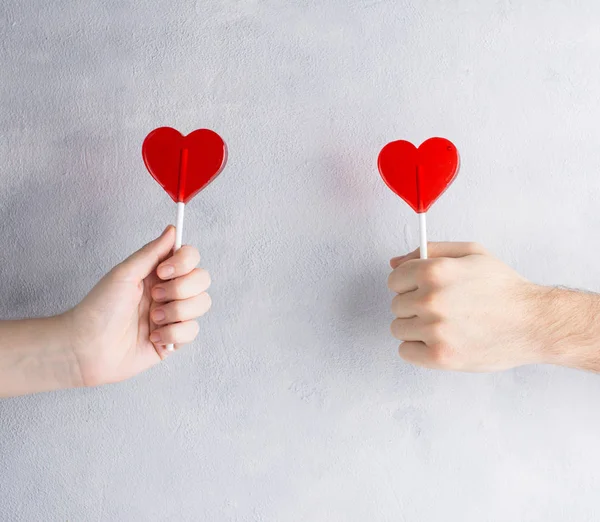 Şeker kalpler el erkek ve kadınlarda beton zemin üzerine. 