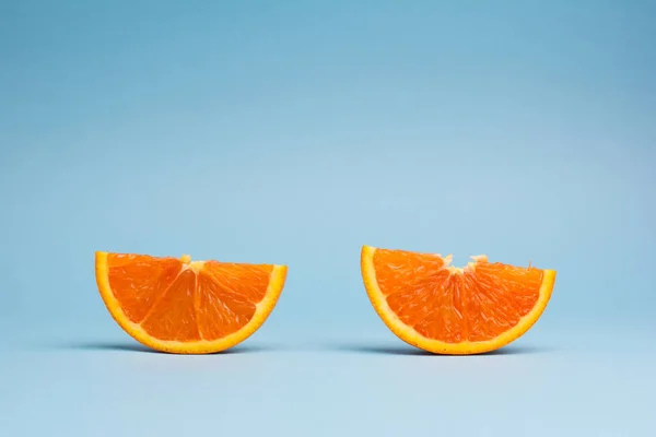 Turuncu meyve üzerinde mavi arka plan izole iki dilim