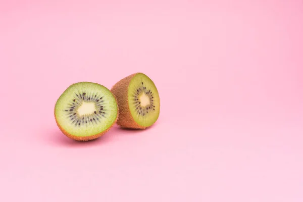 Pastel pembe bir arka plan üzerinde Yarım kesimli kivi.