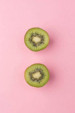 Pastel pembe bir arka plan üzerinde Yarım kesimli kivi